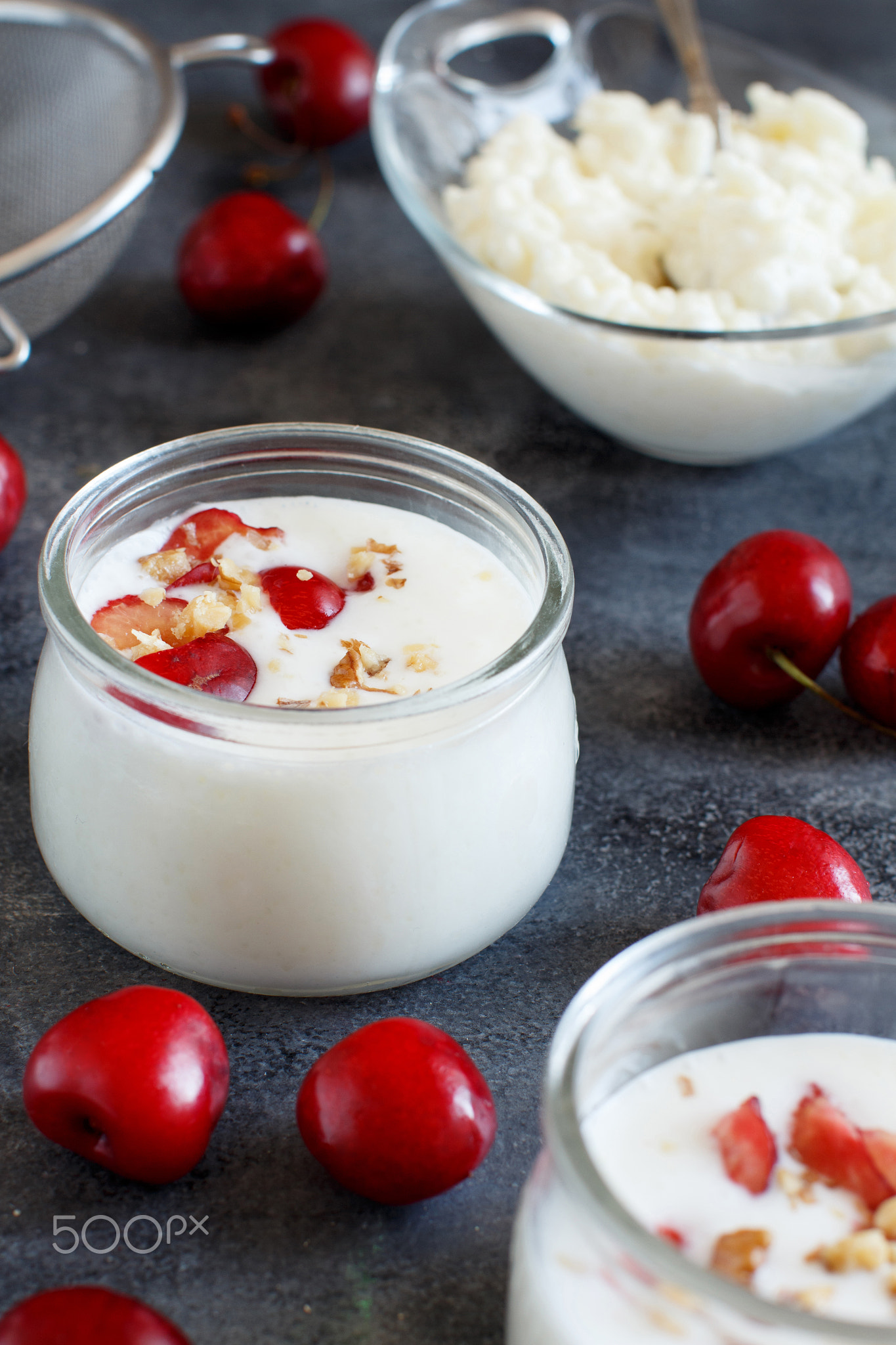 Fermented yogurt kefir in small bottles with cherries and walnut